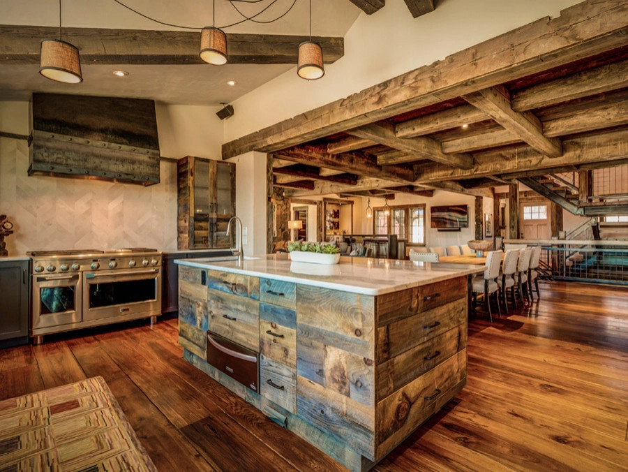 Foto di un cucina con isola centrale stile rurale con parquet scuro, pavimento marrone e travi a vista