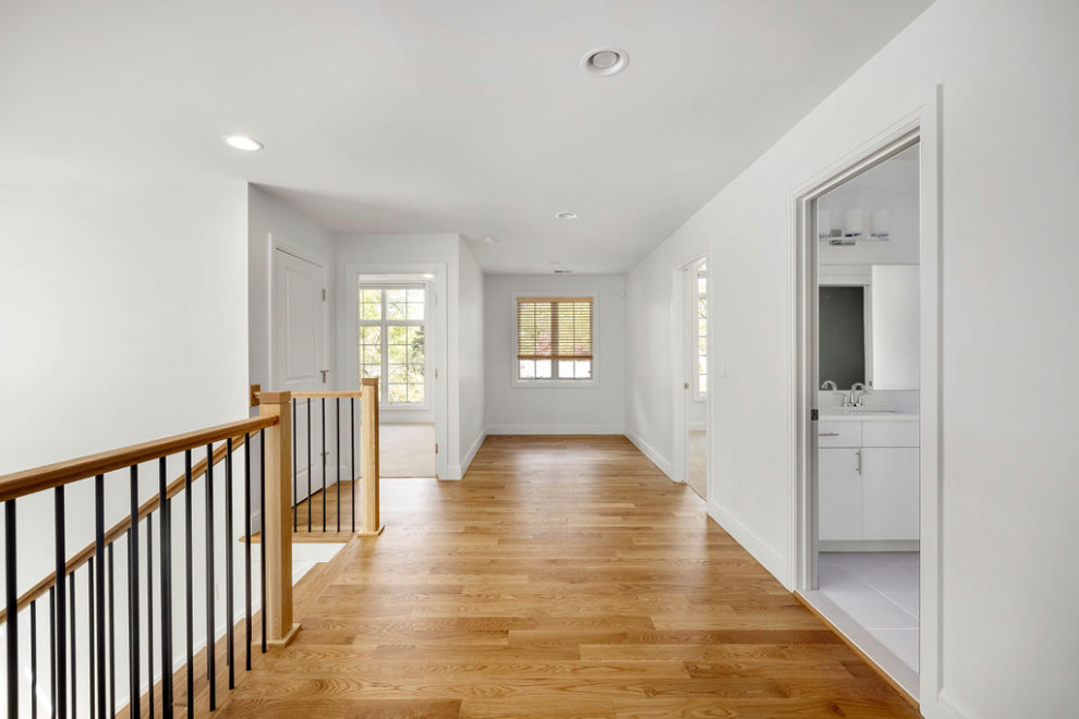 This is an example of a transitional hallway in Detroit with medium hardwood floors.
