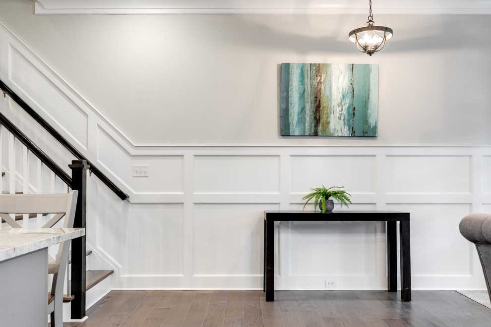 Inspiration for a mid-sized traditional foyer in Richmond with grey walls, medium hardwood floors, a single front door, a medium wood front door, brown floor and decorative wall panelling.
