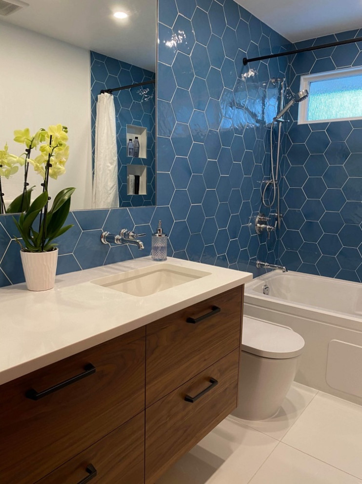 Exemple d'une salle de bain moderne en bois foncé de taille moyenne avec un placard à porte plane, une baignoire en alcôve, un combiné douche/baignoire, WC à poser, un carrelage bleu, des carreaux de porcelaine, un mur blanc, un sol en carrelage de porcelaine, un lavabo intégré, un plan de toilette en quartz modifié, un sol blanc, une cabine de douche avec un rideau, un plan de toilette blanc, une niche, meuble simple vasque et meuble-lavabo suspendu.
