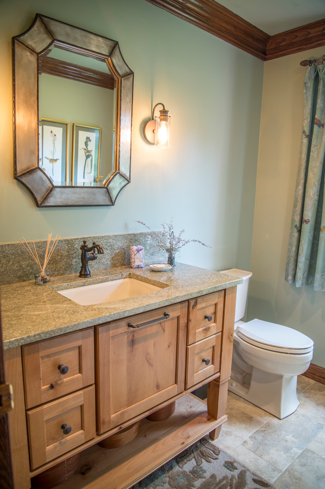 This is an example of a small country powder room in Chicago with flat-panel cabinets, light wood cabinets, a two-piece toilet, beige tile, ceramic tile, green walls, porcelain floors, an undermount sink and granite benchtops.