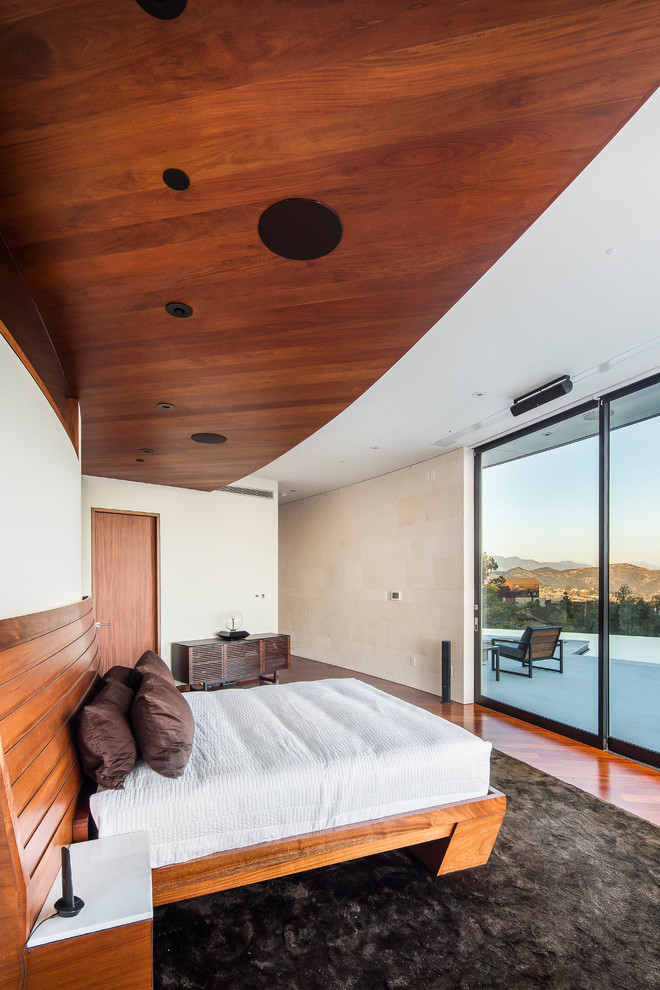 Photo of a large contemporary master bedroom in Los Angeles with beige walls, medium hardwood floors, no fireplace and red floor.