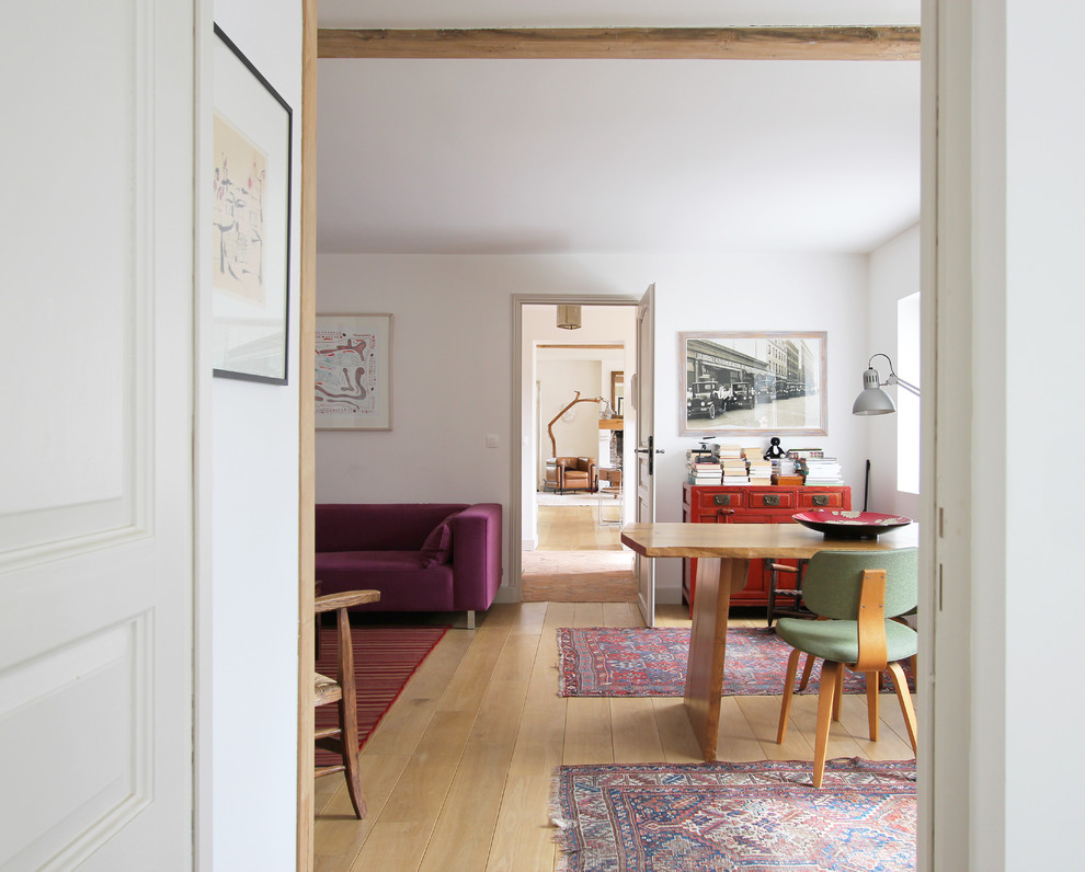 Inspiration for a midcentury dining room in Paris with white walls and medium hardwood floors.