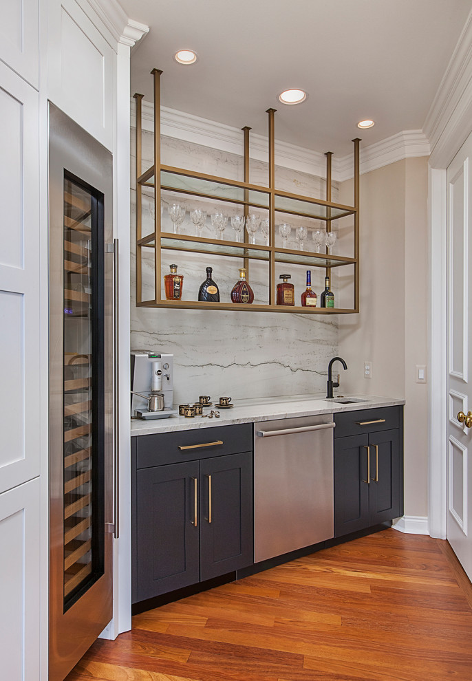 Inspiration for a mid-sized transitional single-wall wet bar in Detroit with an undermount sink, shaker cabinets, black cabinets, quartzite benchtops, white splashback, medium hardwood floors, brown floor and white benchtop.