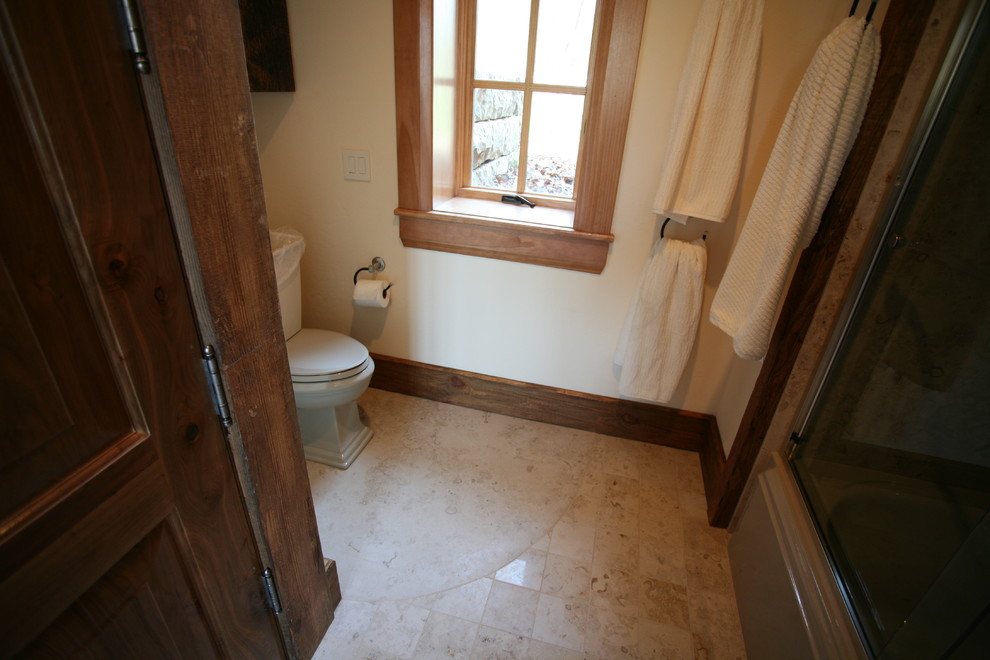 Example of a mid-sized mountain style 3/4 porcelain tile and beige floor alcove shower design with furniture-like cabinets, medium tone wood cabinets, a two-piece toilet, yellow walls, an integrated sink, granite countertops and a hinged shower door