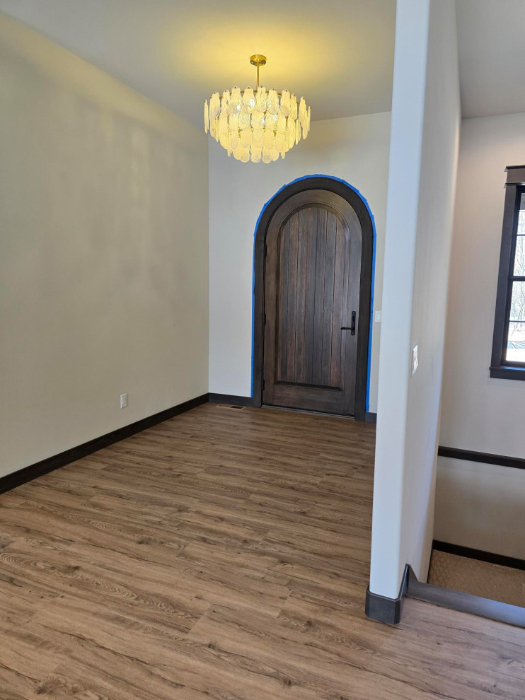Transitional vinyl floor and brown floor single front door photo with beige walls and a dark wood front door