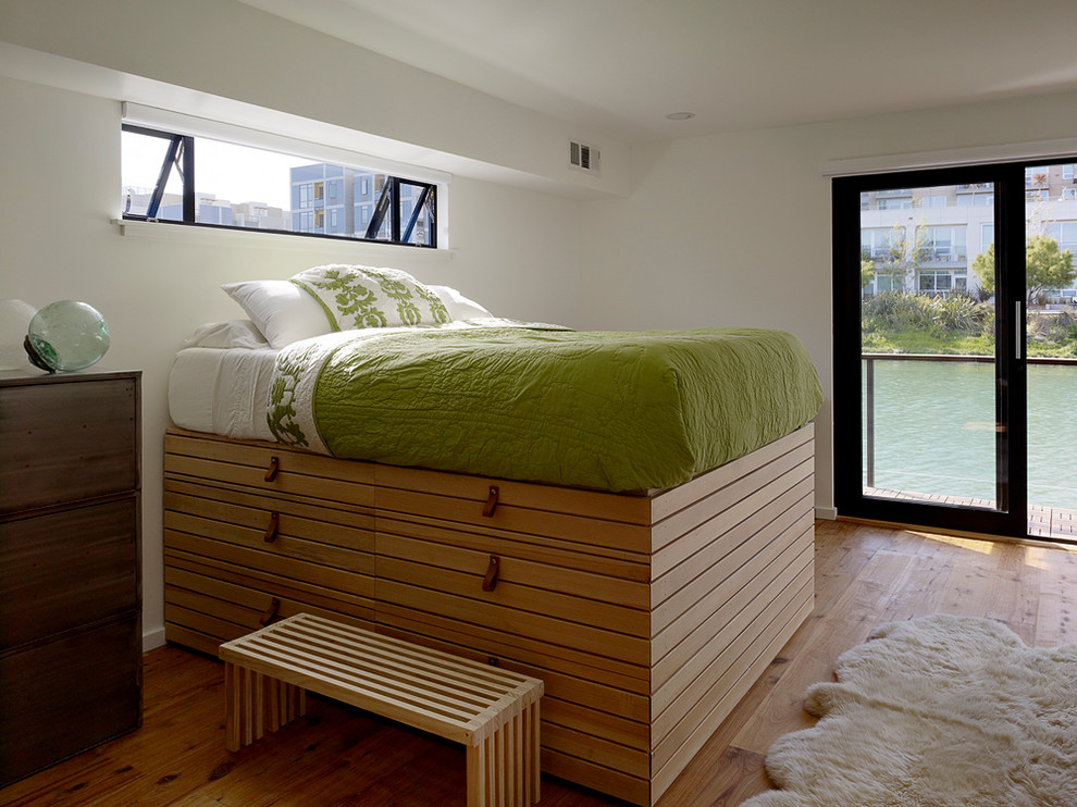 Design ideas for a modern bedroom in San Francisco with white walls and medium hardwood floors.