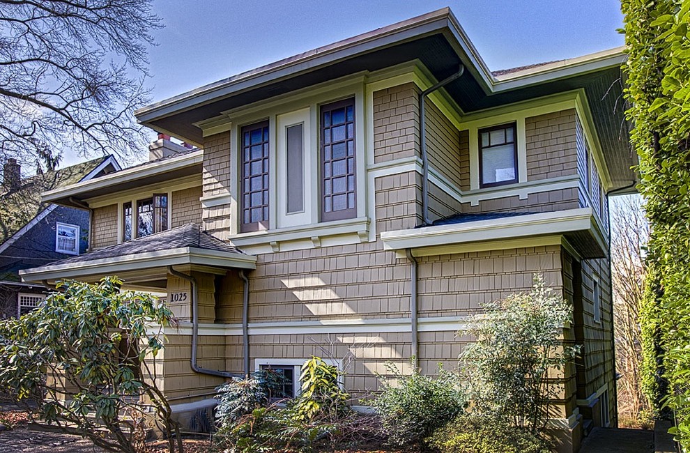 This is an example of a large arts and crafts two-storey brown exterior in Seattle with wood siding.