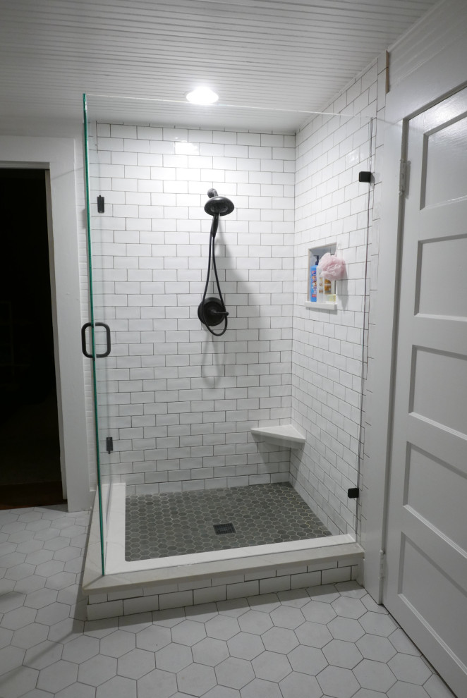 На фото: детская ванная комната среднего размера в классическом стиле с фасадами островного типа, синими фасадами, отдельно стоящей ванной, угловым душем, раздельным унитазом, белой плиткой, керамической плиткой, белыми стенами, полом из керамогранита, врезной раковиной, столешницей из искусственного кварца, белым полом, душем с распашными дверями, белой столешницей, нишей, тумбой под одну раковину, напольной тумбой, деревянным потолком и деревянными стенами с
