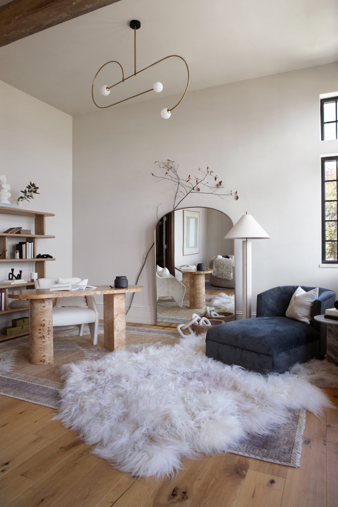 Foto de despacho minimalista grande con paredes blancas, todas las chimeneas, marco de chimenea de piedra, escritorio independiente, suelo marrón y vigas vistas