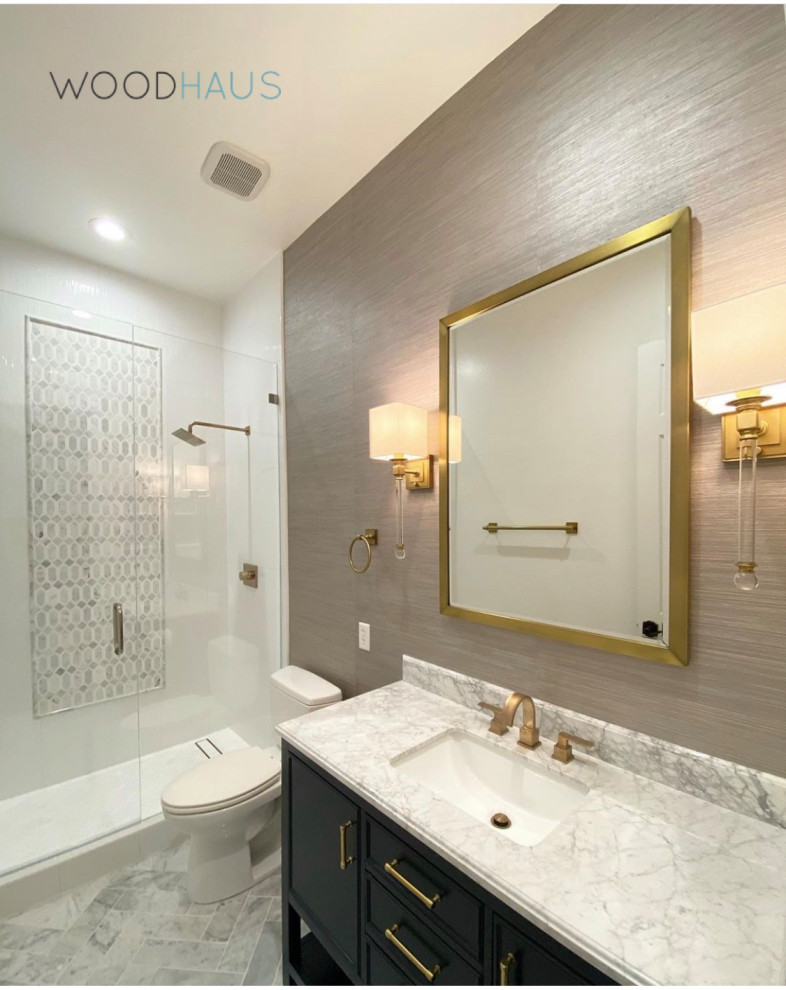 Mid-sized contemporary master bathroom in Miami with shaker cabinets, blue cabinets, an alcove shower, a two-piece toilet, white tile, porcelain tile, brown walls, marble floors, an undermount sink, marble benchtops, white floor, a hinged shower door, white benchtops, a single vanity, a freestanding vanity and wallpaper.