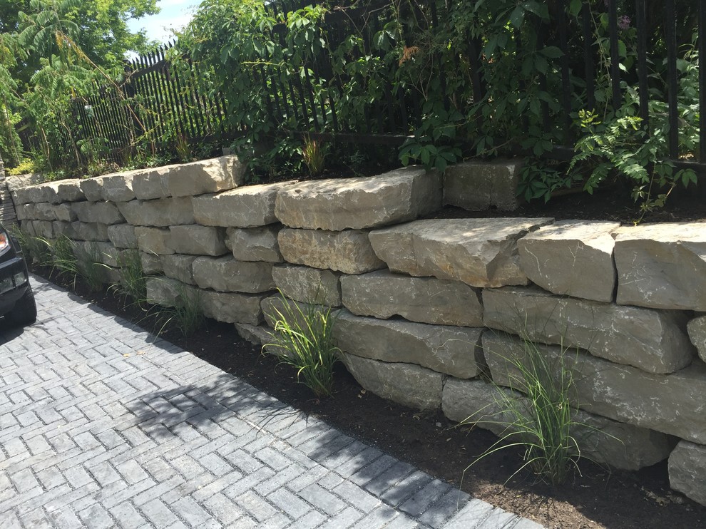 Photo of a mid-sized rustic partial sun front yard stone driveway in Orange County for summer.