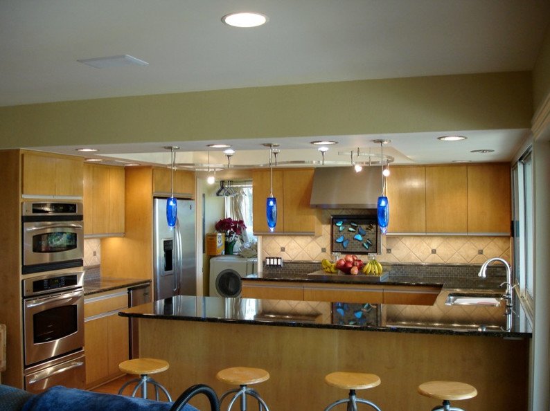 Transitional u-shaped kitchen pantry photo in Austin with flat-panel cabinets, light wood cabinets, beige backsplash, stainless steel appliances and no island