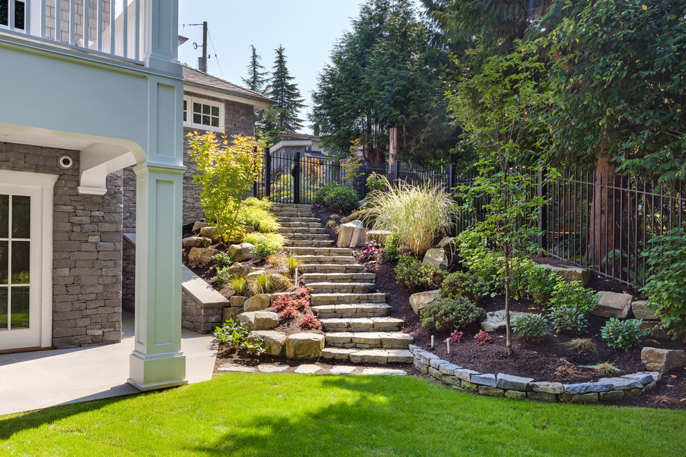 Expansive traditional front yard full sun formal garden in Vancouver with a fire feature and natural stone pavers for spring.