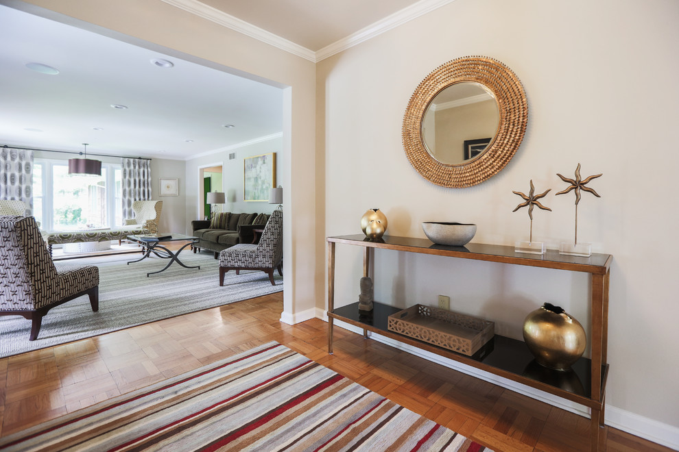 Example of a mid-sized transitional medium tone wood floor and brown floor foyer design in Los Angeles with beige walls