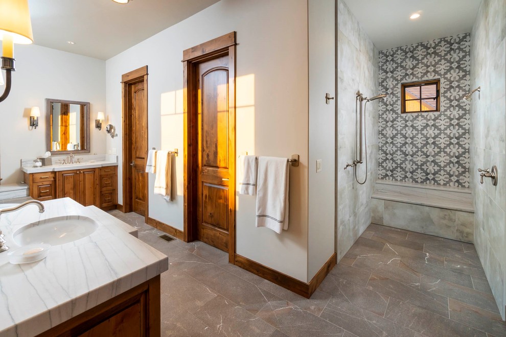 Inspiration for a mid-sized country master bathroom in Other with raised-panel cabinets, medium wood cabinets, a drop-in tub, an open shower, beige walls, an undermount sink, marble benchtops, brown floor and white benchtops.