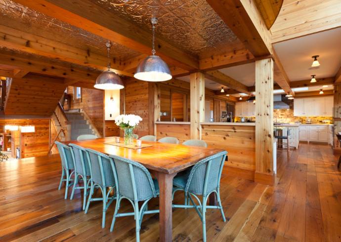 Inspiration for a large rustic medium tone wood floor and brown floor great room remodel in Denver with no fireplace
