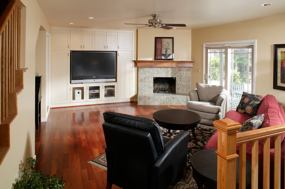 This is an example of a large contemporary enclosed family room in Sacramento with a game room, yellow walls, dark hardwood floors, a standard fireplace, a tile fireplace surround and a freestanding tv.