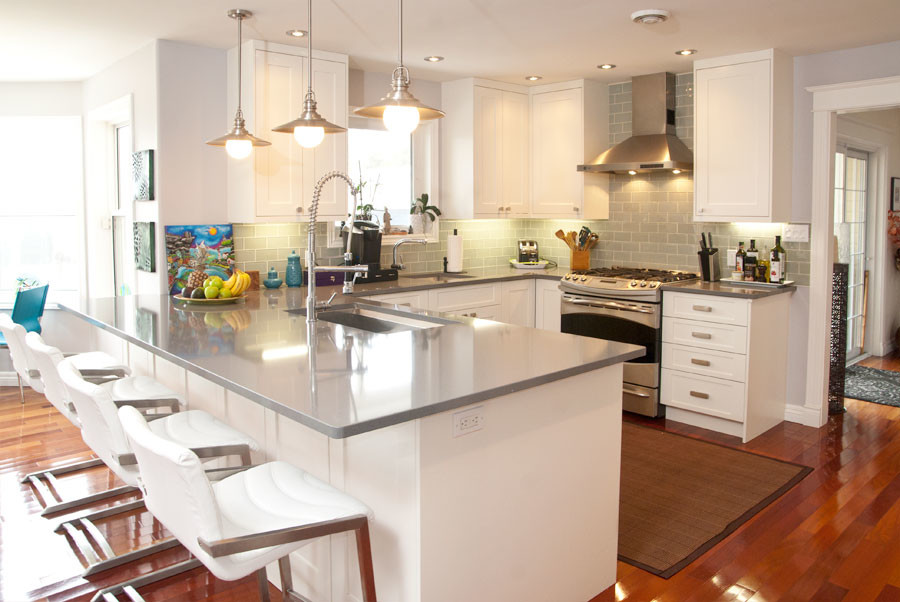 Inspiration for a small transitional u-shaped dark wood floor eat-in kitchen remodel with an undermount sink, shaker cabinets, white cabinets, quartzite countertops, gray backsplash, glass tile backsplash, stainless steel appliances and a peninsula