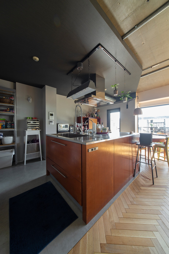 Bild på ett retro kök med öppen planlösning, med en undermonterad diskho, luckor med profilerade fronter, skåp i mörkt trä, bänkskiva i rostfritt stål, vita vitvaror, vinylgolv, en köksö och grått golv