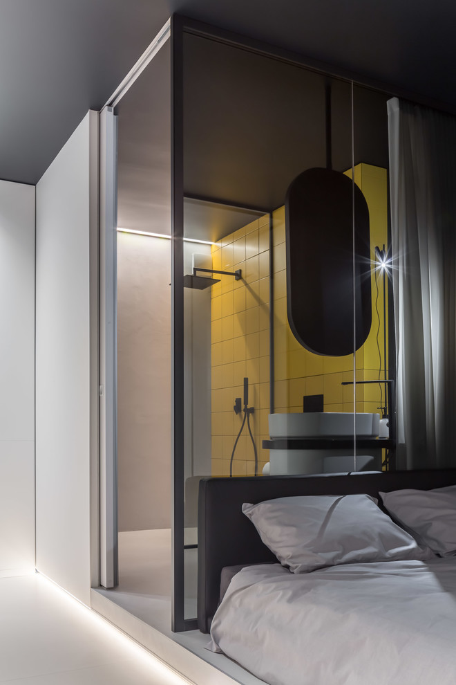 This is an example of a mid-sized contemporary 3/4 bathroom in Other with furniture-like cabinets, white cabinets, a curbless shower, a wall-mount toilet, yellow tile, ceramic tile, black walls, a pedestal sink, grey floor, an open shower and black benchtops.