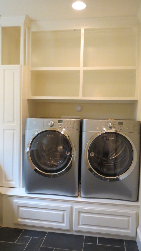This is an example of a large traditional dedicated laundry room in Raleigh with a single-bowl sink, raised-panel cabinets, white cabinets, granite benchtops, beige walls, ceramic floors and a side-by-side washer and dryer.
