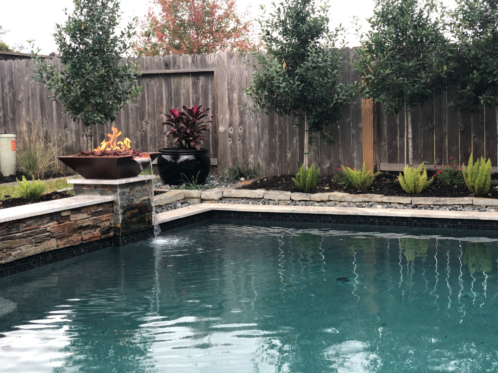Foto de piscina natural bohemia de tamaño medio en patio trasero con losas de hormigón