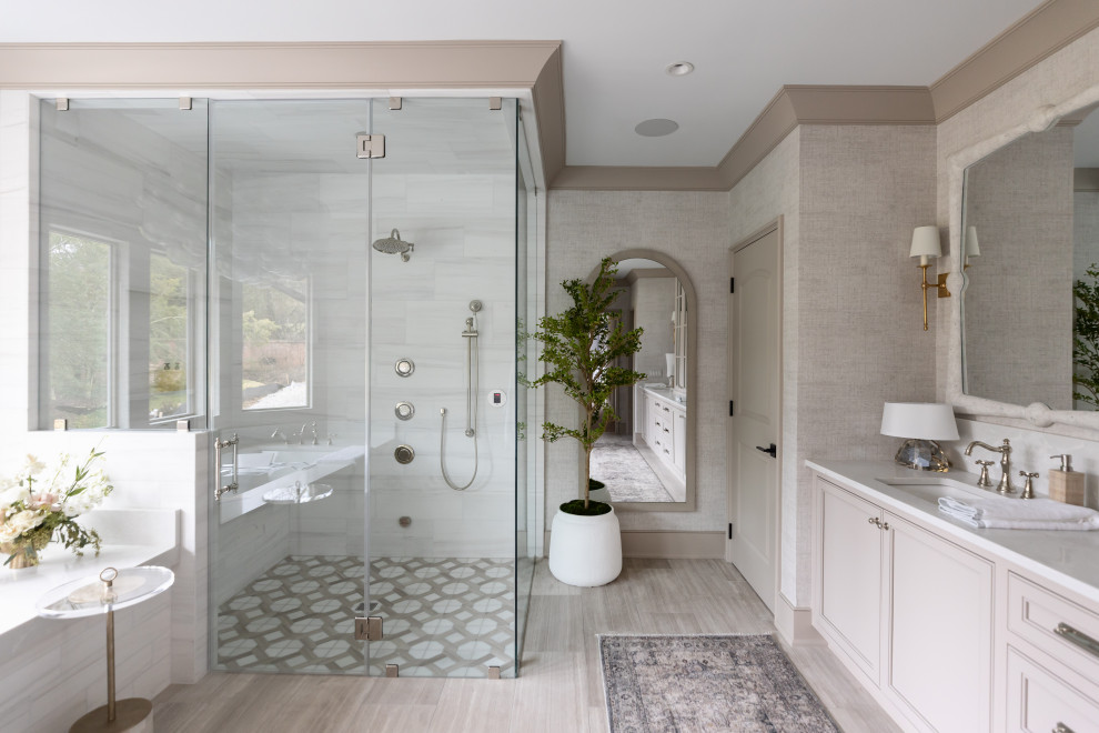 Shower bench - coastal master white tile porcelain tile, double-sink, wallpaper and gray floor shower bench idea in Nashville with beige cabinets, a hinged shower door, a built-in vanity, recessed-panel cabinets, an undermount tub, gray walls, an undermount sink and white countertops