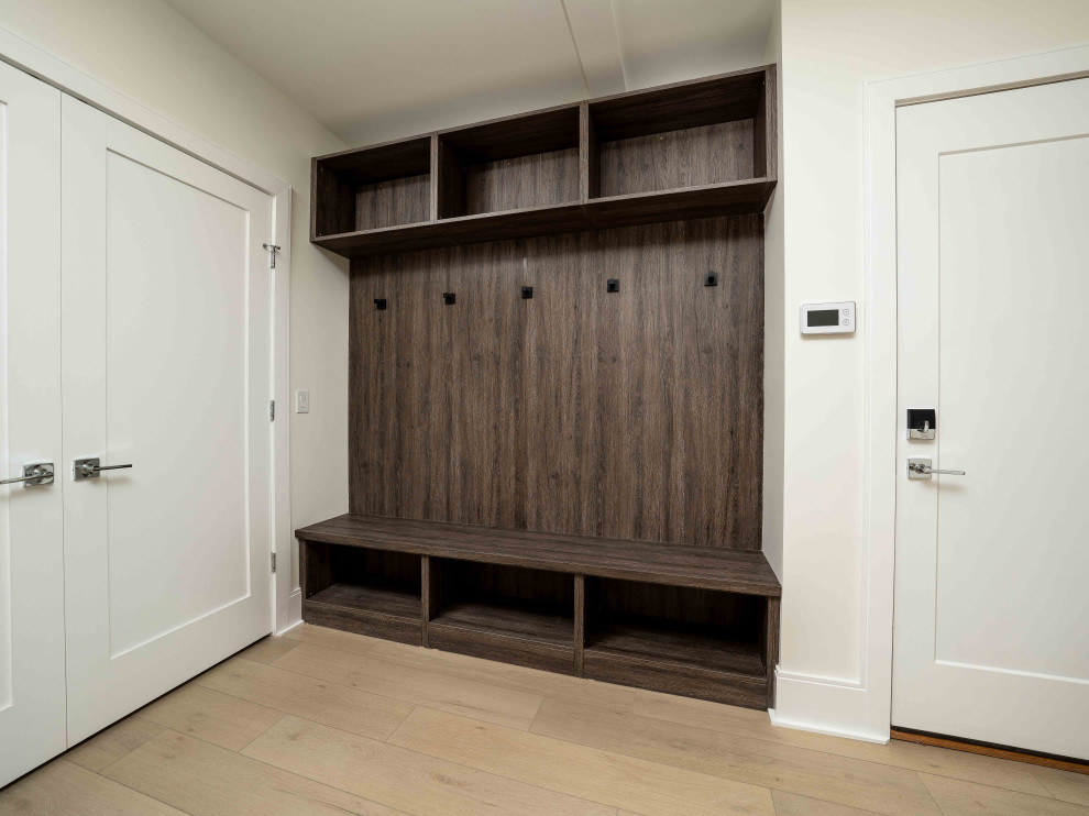 Example of a minimalist mudroom design in Boston with white walls and a white front door
