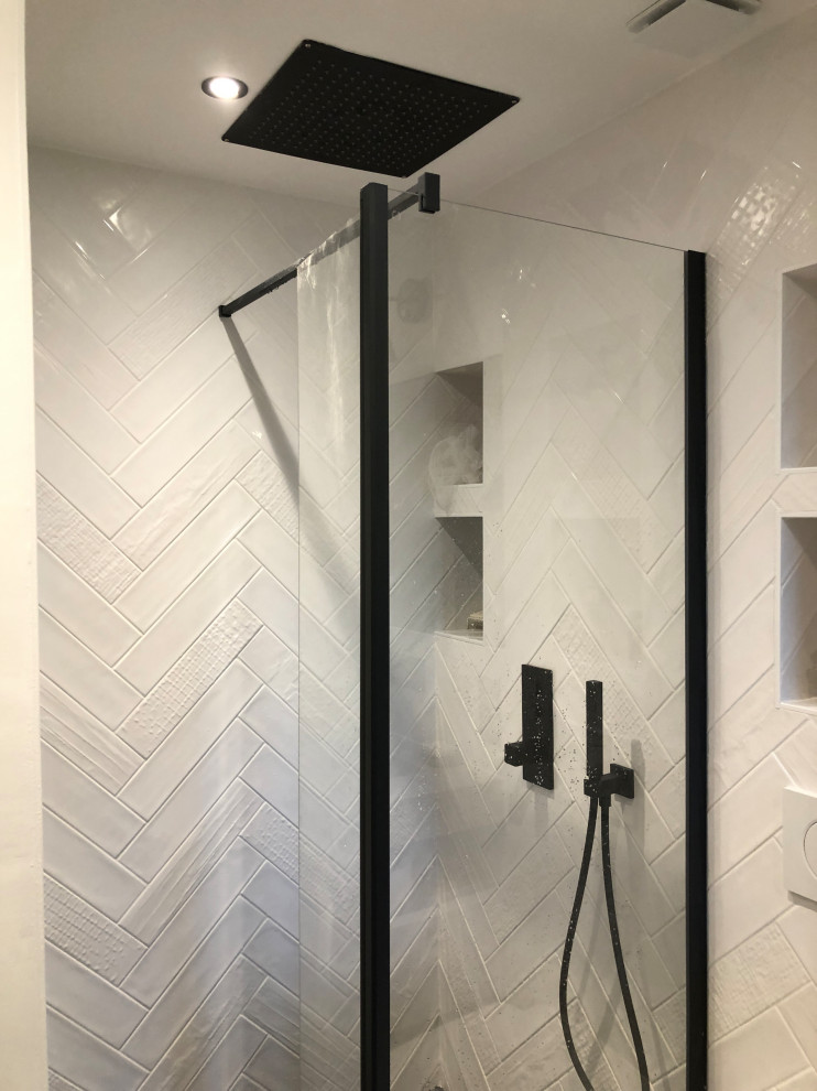 Inspiration för små klassiska en-suite badrum, med en kantlös dusch, en vägghängd toalettstol, vit kakel, vita väggar, cementgolv, ett väggmonterat handfat, laminatbänkskiva och blått golv