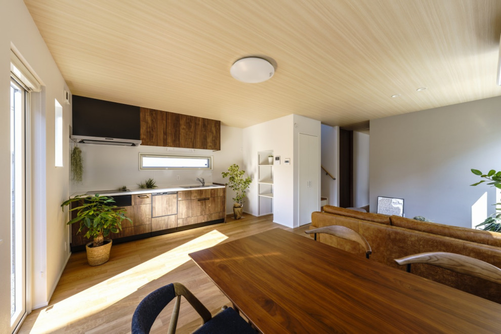 Идея дизайна: отдельная, прямая кухня среднего размера в стиле модернизм с коричневыми фасадами, столешницей из акрилового камня, белым фартуком, светлым паркетным полом, коричневым полом, потолком с обоями и мойкой у окна
