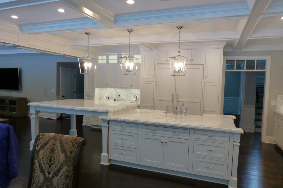 Example of a large transitional l-shaped dark wood floor and brown floor open concept kitchen design in Providence with a farmhouse sink, beaded inset cabinets, white cabinets, marble countertops, white backsplash, marble backsplash, paneled appliances and an island