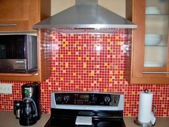Kitchen - mid-sized kitchen idea in Phoenix with shaker cabinets, medium tone wood cabinets, red backsplash and stainless steel appliances