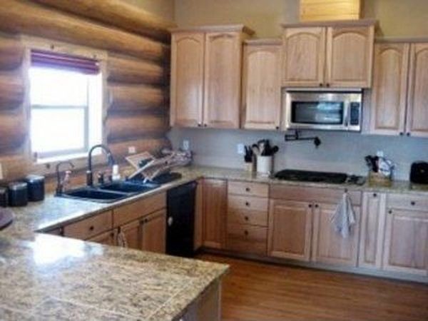 Example of a mid-sized mountain style l-shaped open concept kitchen design with recessed-panel cabinets and light wood cabinets