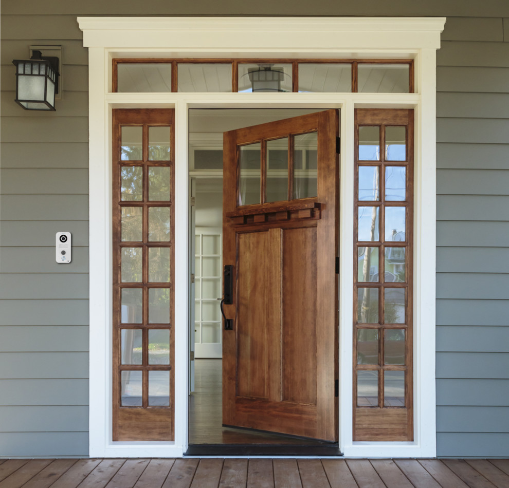 This is an example of a mid-sized arts and crafts front door in San Diego with grey walls, light hardwood floors, a pivot front door, a medium wood front door and brown floor.