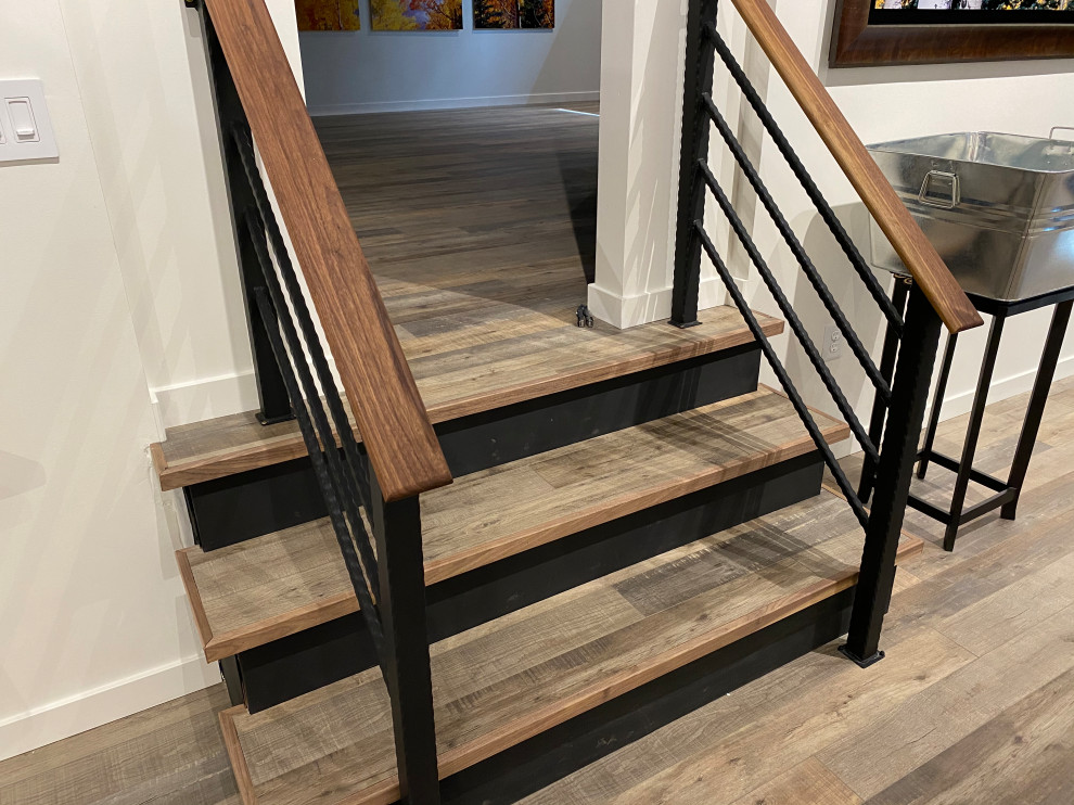 This is an example of a small modern wood straight metal railing staircase in Denver with wood risers.