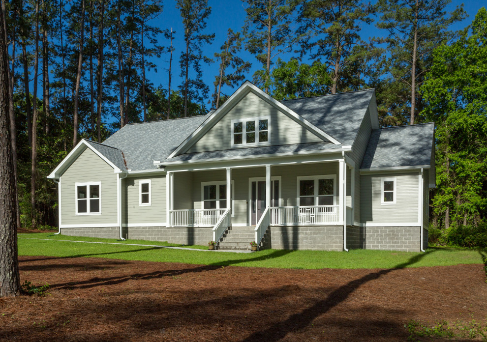 Cette photo montre une façade de maison grise chic en bardage à clin de taille moyenne et de plain-pied avec un revêtement en vinyle, un toit à deux pans, un toit en shingle et un toit gris.