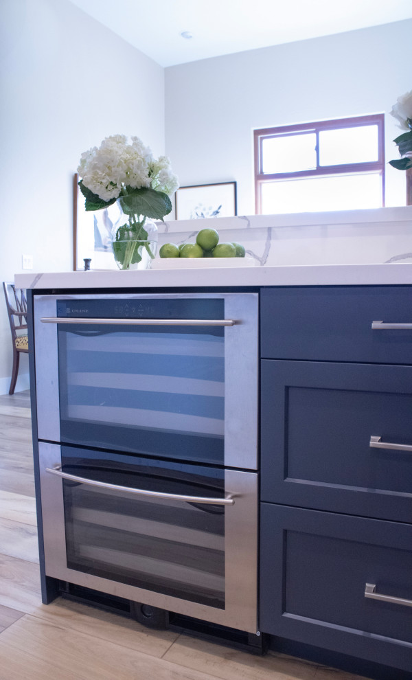 Example of a mid-sized transitional eat-in kitchen design in Phoenix with an undermount sink, shaker cabinets, blue cabinets, quartz countertops, white backsplash, quartz backsplash, stainless steel appliances, an island and white countertops