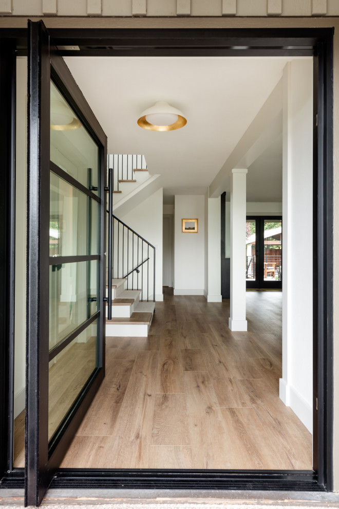 Inspiration for a mid-sized contemporary medium tone wood floor entryway remodel in Richmond with a glass front door