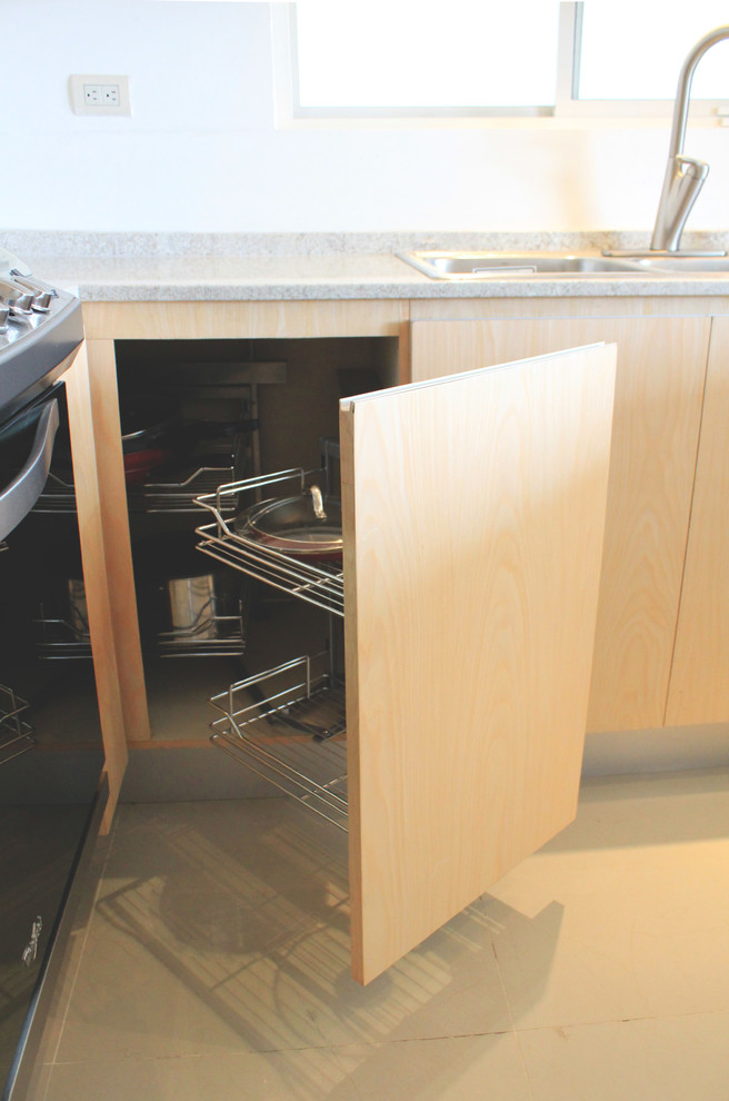 Example of a mid-sized minimalist u-shaped porcelain tile eat-in kitchen design with a double-bowl sink, flat-panel cabinets, light wood cabinets, granite countertops and stainless steel appliances