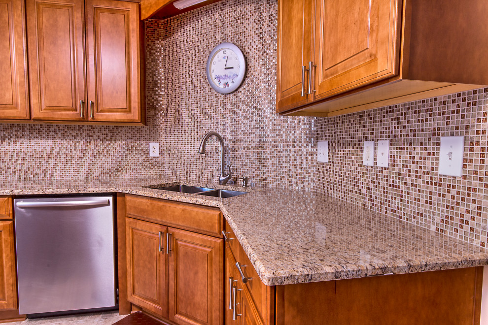 Example of a mid-sized l-shaped cement tile floor eat-in kitchen design with an undermount sink, raised-panel cabinets, medium tone wood cabinets, granite countertops, brown backsplash, mosaic tile backsplash, stainless steel appliances, an island and brown countertops