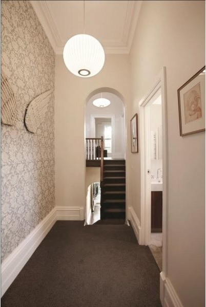 Inspiration for a mid-sized traditional hallway in Melbourne with white walls and carpet.