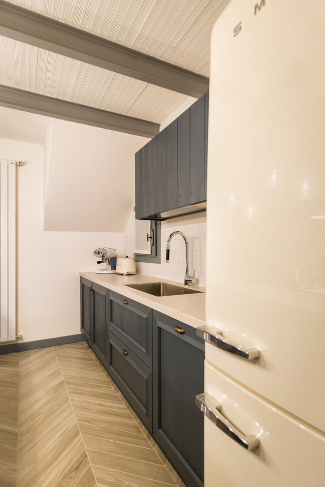 Traditional galley eat-in kitchen in Venice with a single-bowl sink, raised-panel cabinets, grey cabinets, quartz benchtops, white splashback, ceramic splashback, porcelain floors and a peninsula.