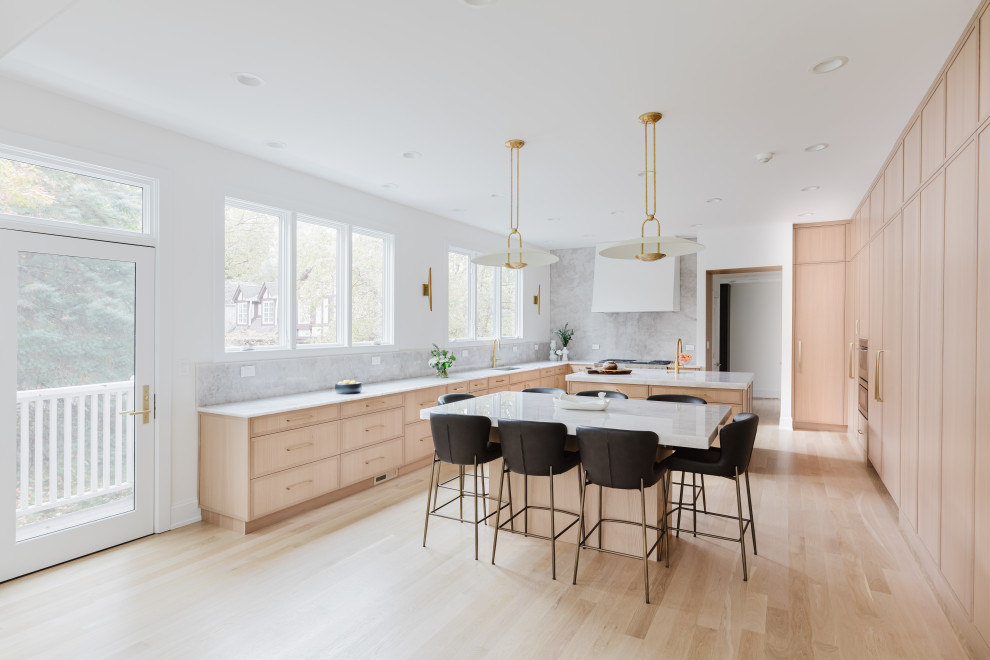 Modern Bright Kitchen With Marble Island and Large Windows Overlooking Greenery