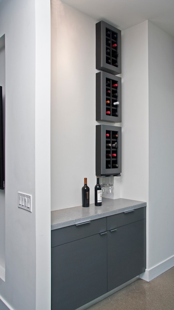 Inspiration for a mid-sized contemporary galley home bar in Grand Rapids with flat-panel cabinets, an undermount sink, grey cabinets, quartz benchtops, concrete floors, grey floor and grey benchtop.