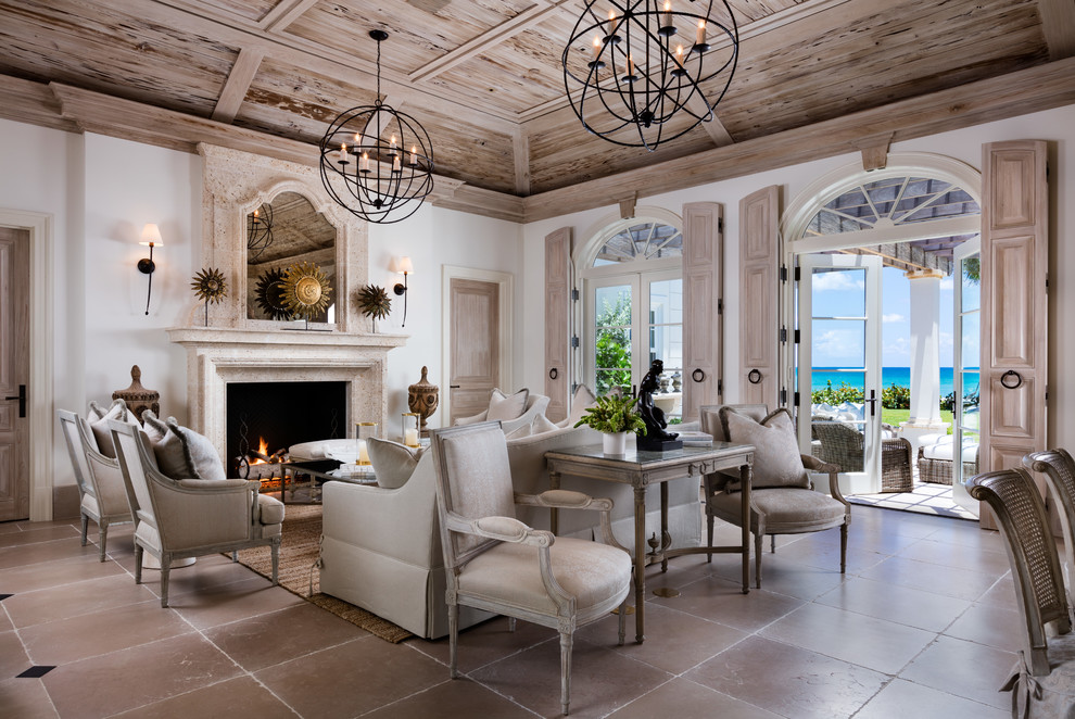 Photo of a mid-sized mediterranean formal open concept living room in Denver with white walls, a standard fireplace, a stone fireplace surround, no tv, ceramic floors and beige floor.