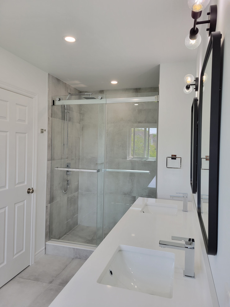 Пример оригинального дизайна: главная ванная комната в стиле модернизм с душем в нише, серой плиткой, керамогранитной плиткой, белыми стенами, полом из керамогранита, врезной раковиной, столешницей из кварцита, серым полом, душем с раздвижными дверями, белой столешницей, тумбой под две раковины и подвесной тумбой