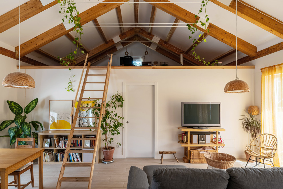 Foto de salón abovedado mediterráneo con paredes blancas, suelo de madera clara, televisor independiente, suelo beige y vigas vistas
