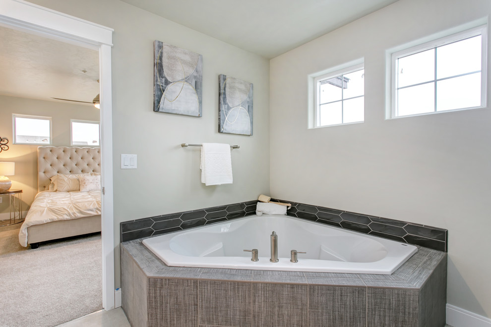 This is an example of a mid-sized contemporary master bathroom in Other with shaker cabinets, dark wood cabinets, a corner tub, an alcove shower, a two-piece toilet, gray tile, ceramic tile, grey walls, vinyl floors, a drop-in sink, laminate benchtops and white floor.