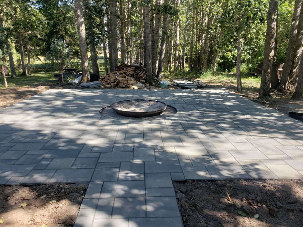Design ideas for a large rustic shade backyard concrete paver landscaping in Edmonton with a fire pit for summer.